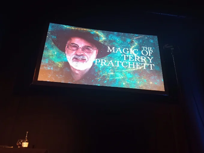 A giant painting of Terry projected into a screen above the stage
