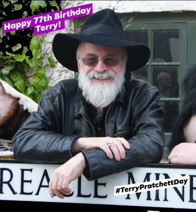 Photo of Terry Pratchett leaning on a street name post based on one of his street in Ankh-Morpork