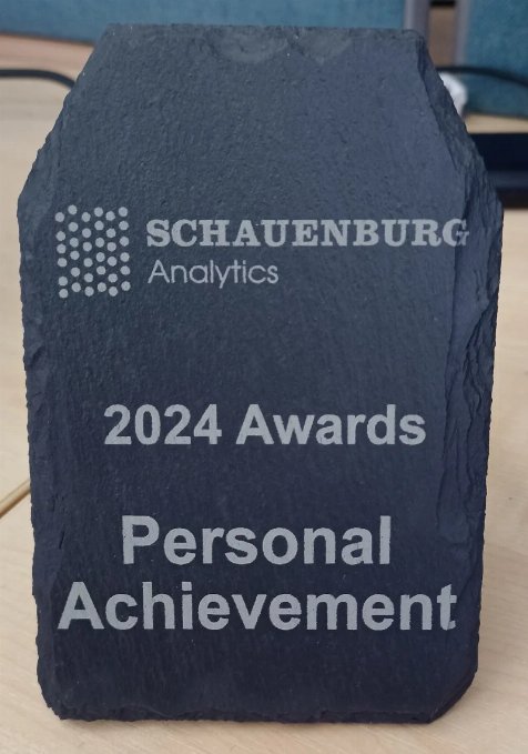 Photo of a rectangular piece of Welsh slate with the words Schauenburg Analytics 2024 Awards Personal Achievement