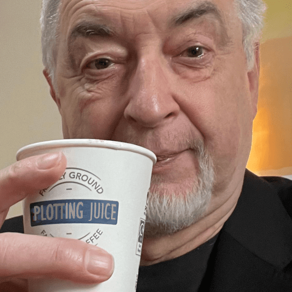 Photos of Stephen Briggs holding  a coffee mug that states Plotting Juice badly photoshopped