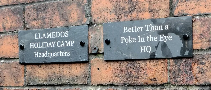 Photo of Llamedos Holiday Camp and Better Than a Poke in the Eye signs